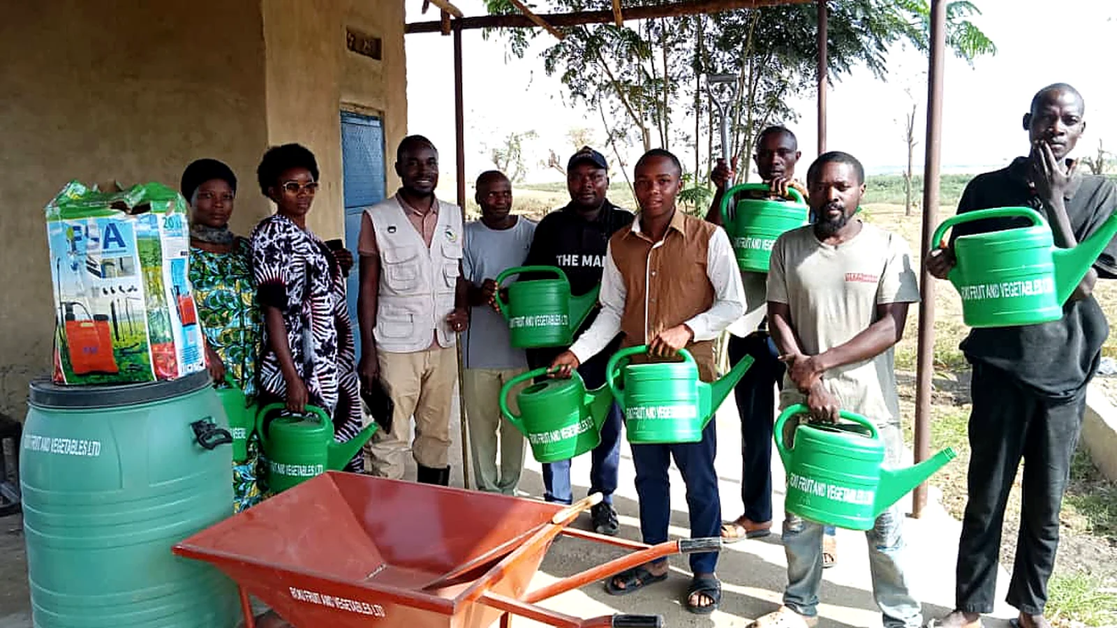 Roki Fruits Uganda team and farmers with agricultural equipment in Isingiro, Western Uganda